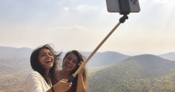 Selfie-Stick mit Smartphone am Aussichtspunkt